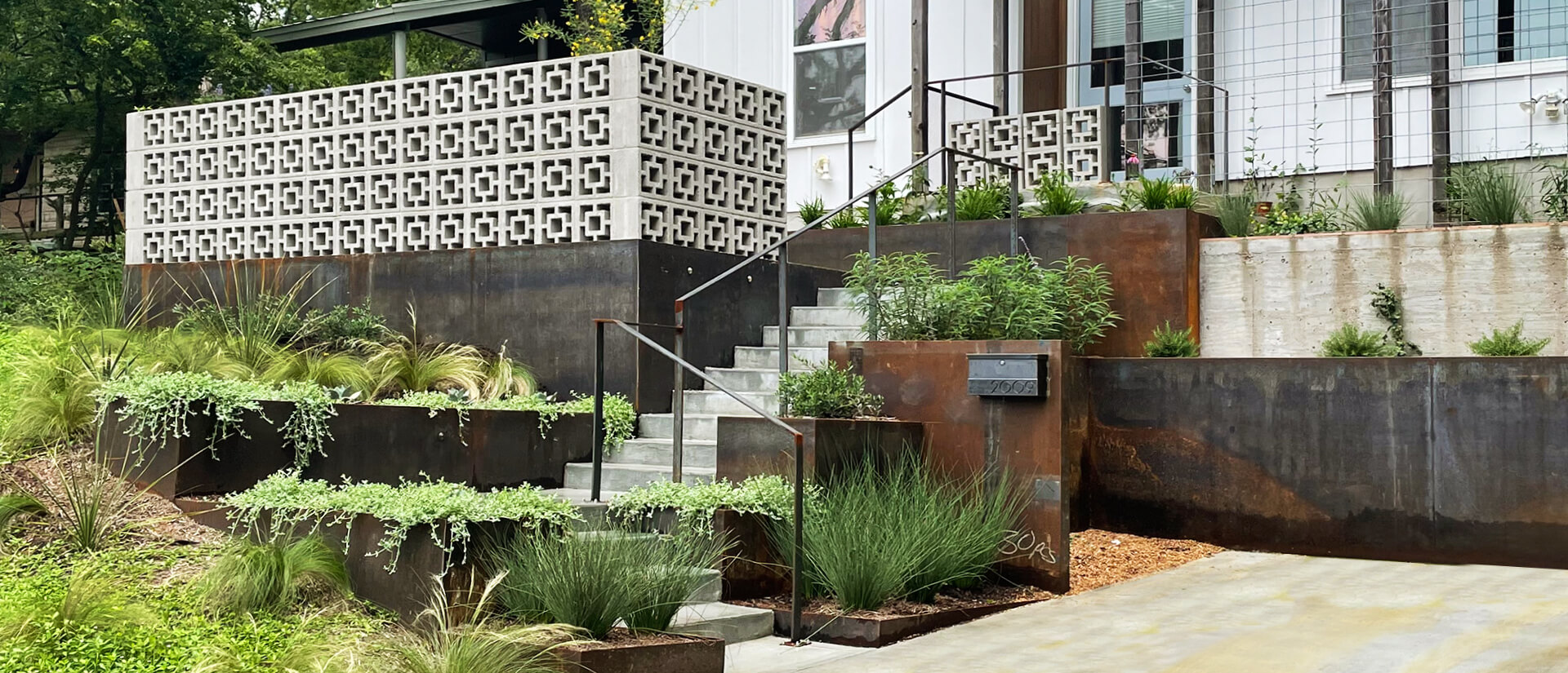 Modern landscape design featuring native plants and steel planters