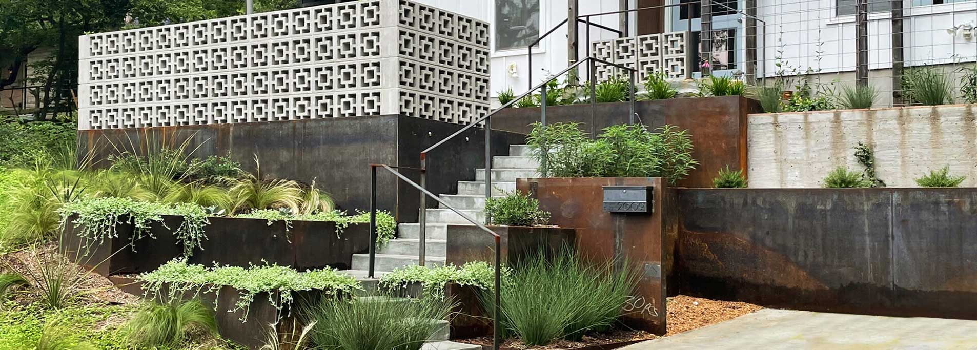 Modern landscape design featuring native plants and steel planters